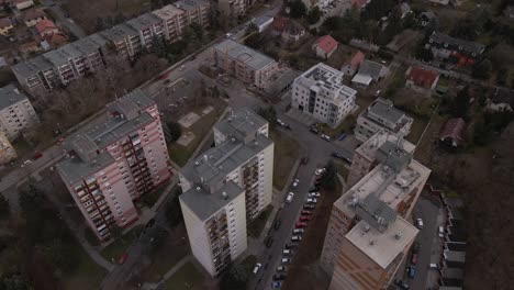 flying over three residential apartment buildings in the middle of a town.