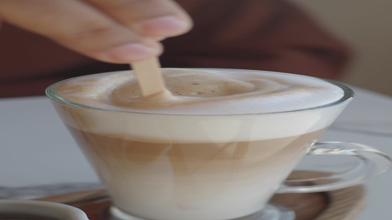 누군가 라테에 거품을 첨가하고 있습니다.