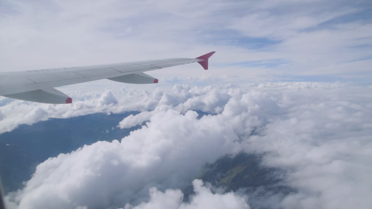 Flyrejse. Vinge af et fly, der flyver over skyerne. Udsigt fra flyvinduet. Flyvemaskine. Rejse. 4K UHD-stockvideooptagelser. 3840X2160