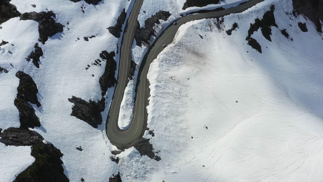 Aerial view of winding road on snow overpass on the side of a mountain in Washington State, Pacific Northwest.