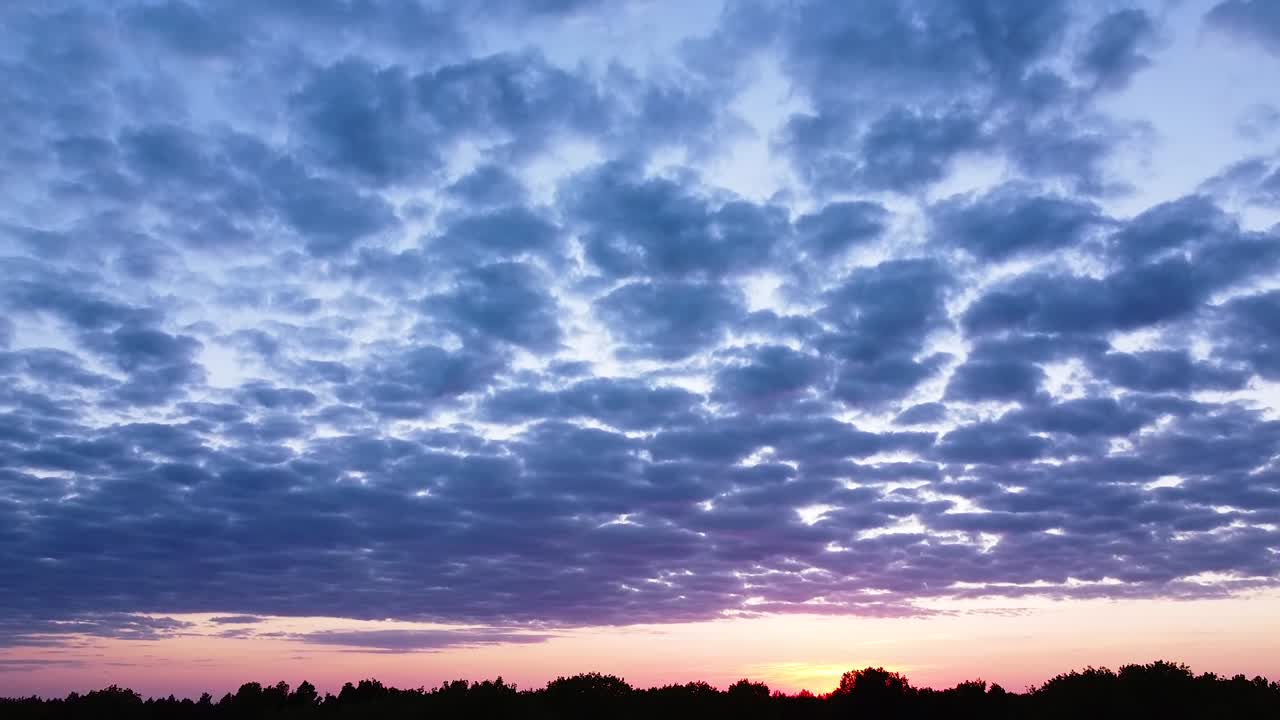 hermosa puesta de sol violeta rosa vibrante aérea de alto contraste con nubes azules sobre el mar báltico en liepaja, barcos distantes en el mar, cámara de tiro de drone ascendente de gran angular inclinada hacia abajo