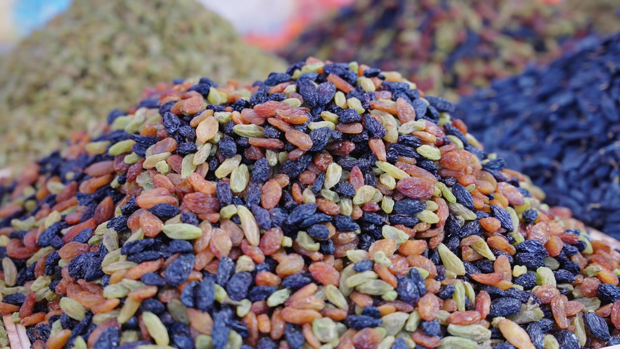 Assorted Xinjiang dried fruits displayed in local specialty shop
Multi-color raisin piles and jujube from Yining China
Closeup view of natural preserved berry and grape snacks