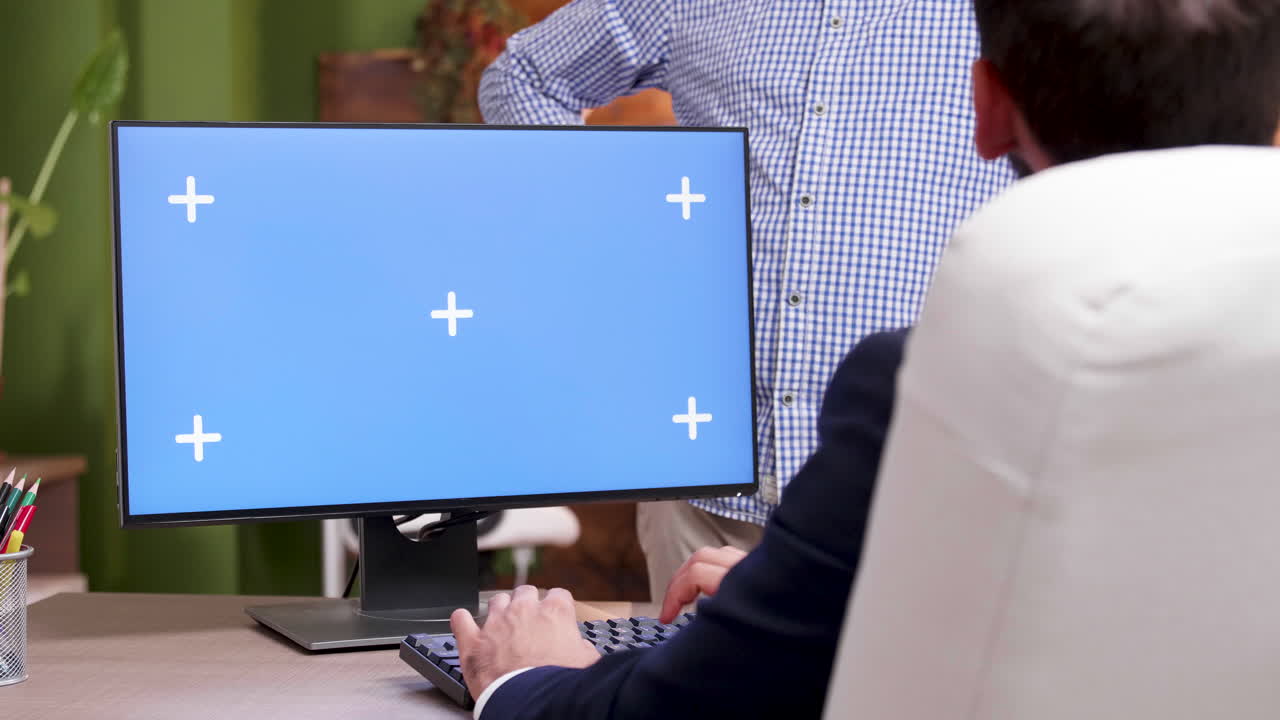 Man working on a computer with a blue screen