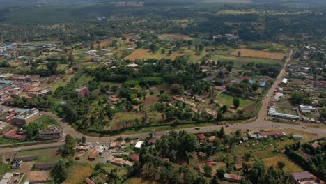 Aerial-view-over-a-town,-revealing-a-forest-fire-and-mountains---tilt,-drone-shot