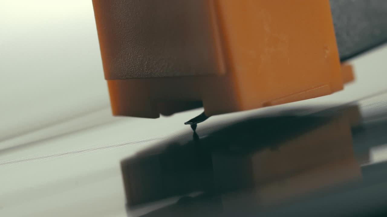 바늘을 가진 스타일러스는 부드럽게 내려와 회전하는 검은 비닐 레코드 (macro) 로 올라갑니다.