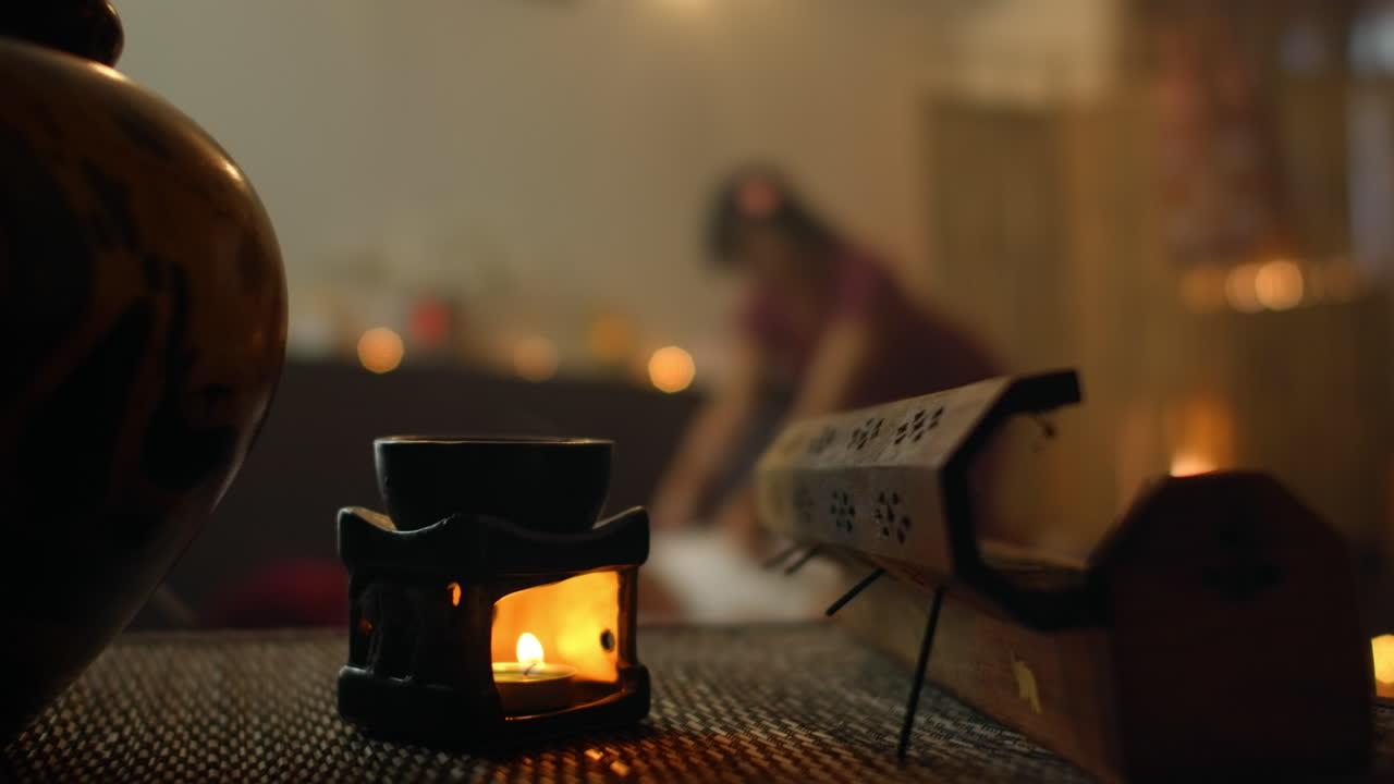 스파에서 여성에게 마사지를하는 태국 마사지. 아시아의 아름다운 여성이 스파에서 태국 허브 마사지 압축 마사지를 받습니다. 그녀는 매우 편안합니다.