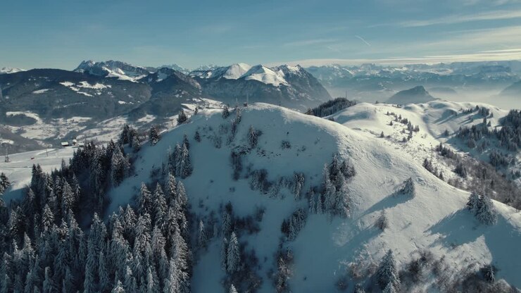 A drone shot of the French alps, mountains, trees and skiing lanes
