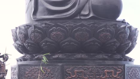 a statue of amitabha buddha sitting on its lotus, surrounded by clouds tranported by the wind, creating an atmosphere of peace, mindfulness and spiritual calmness at fansipan, vietnam's highest point.