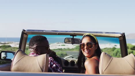 Portrait-of-african-american-couple-sitting-in-the-convertible-car-on-road