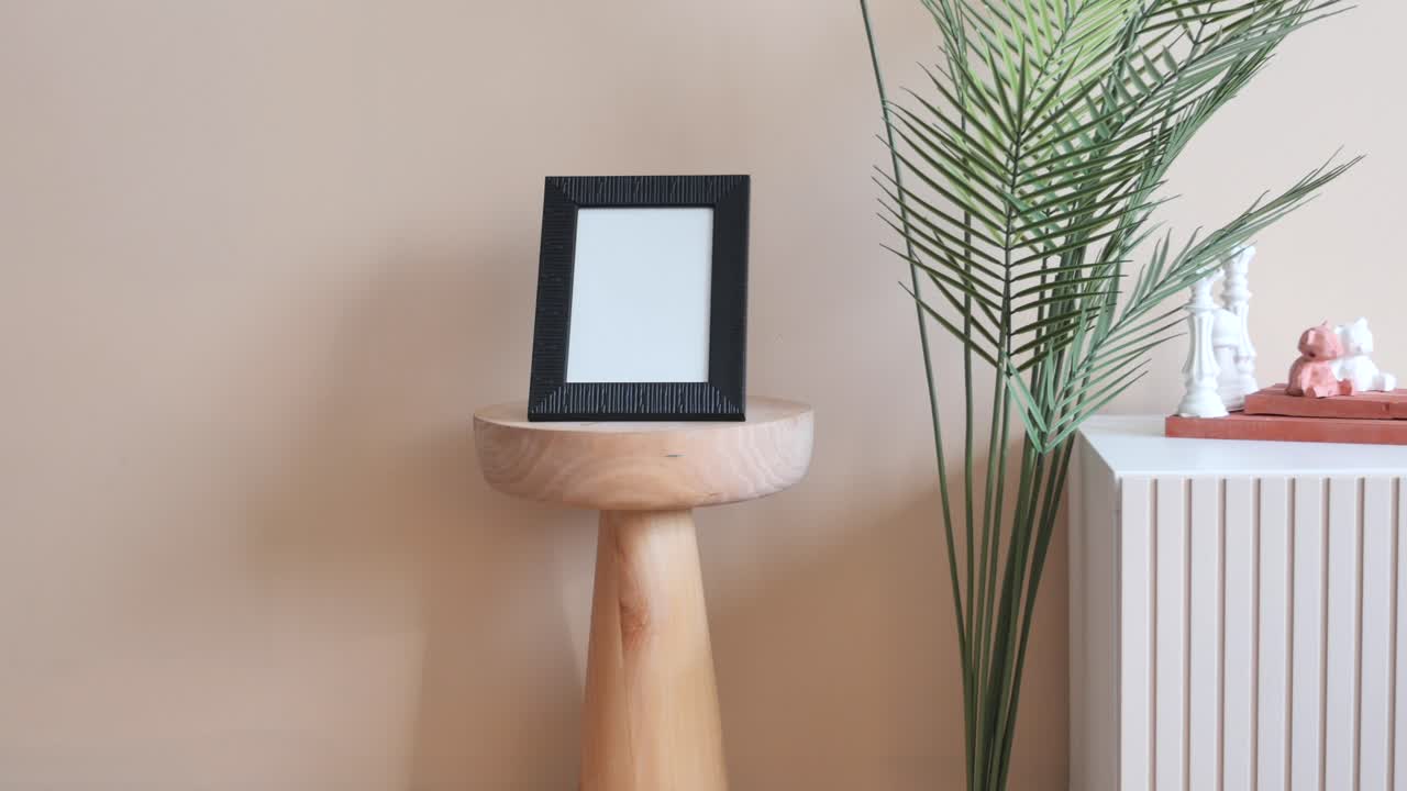 decoración simple del hogar con un marco fotográfico y una planta