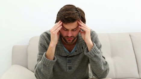 young depressed man sitting on sofa