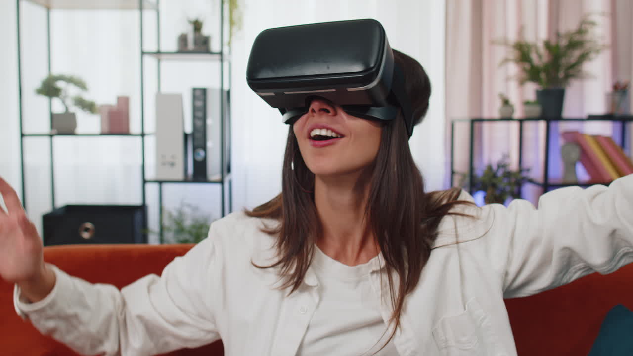 niña joven usa gafas de realidad virtual en casa juega videojuegos en 3d haciendo gestos con las manos