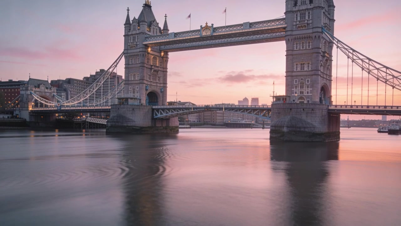 Ondulações se espalhando pelo Rio Tâmisa, uma pequena embarcação passando perto da Tower Bridge causando movimento.