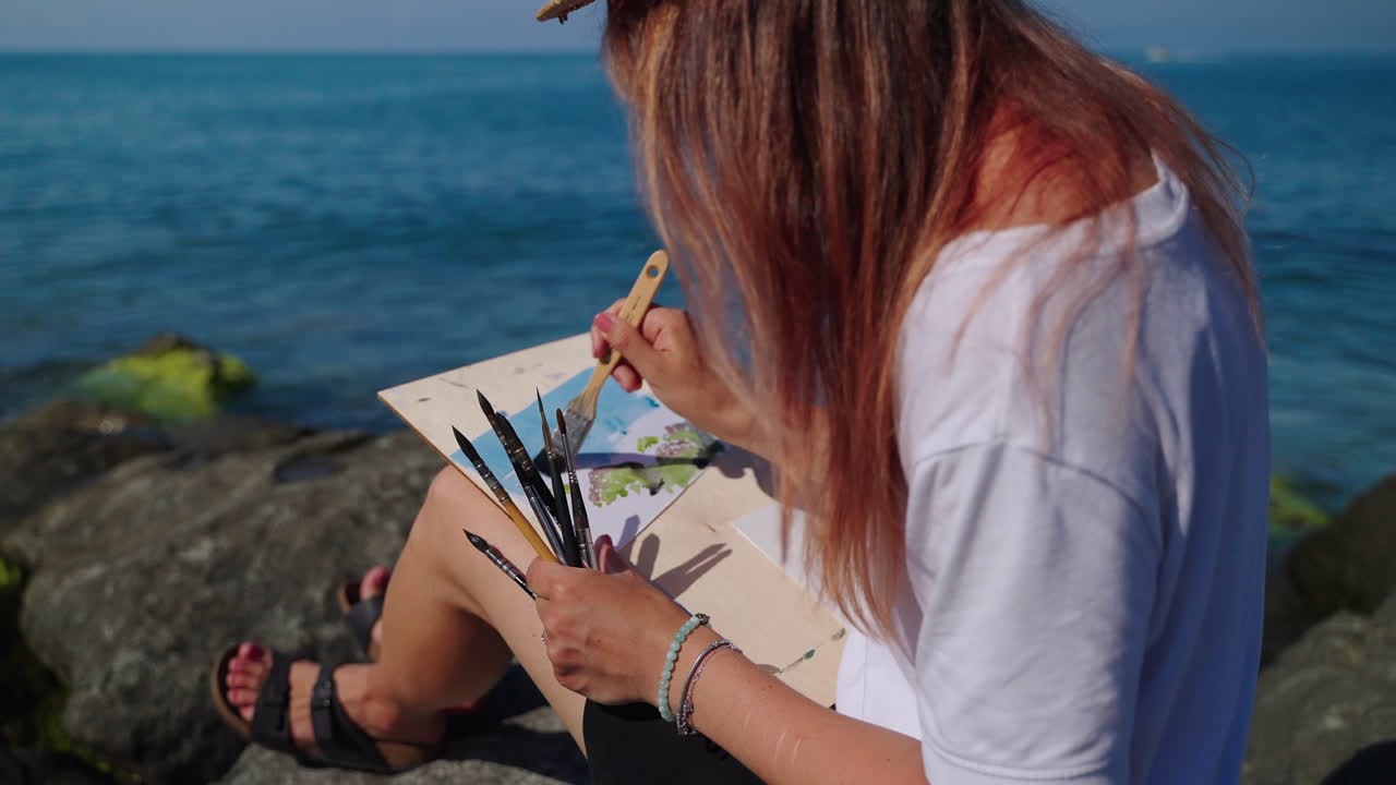 mujer pintando en la playa