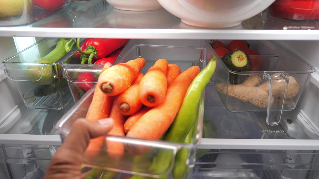 Hand Pulling Out and Storing Fresh Vegetables in Refrigerator