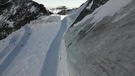 aerial,-ski-slopes-with-mountain-enthusiasts-on-the-top-of-a-icy-mountain-in-winter