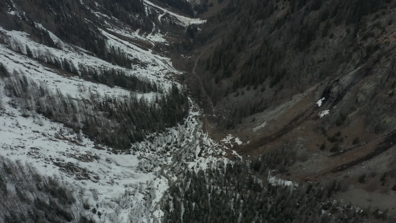 Beautiful aerial of green valley partially covered in snow