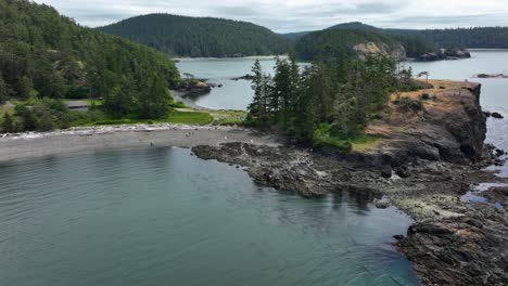 rising drone shot over the rosario head land mass to reveal deception pass and whidbey island in the background