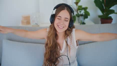 Woman-Dances-on-Sofa-While-Wearing-Headphones