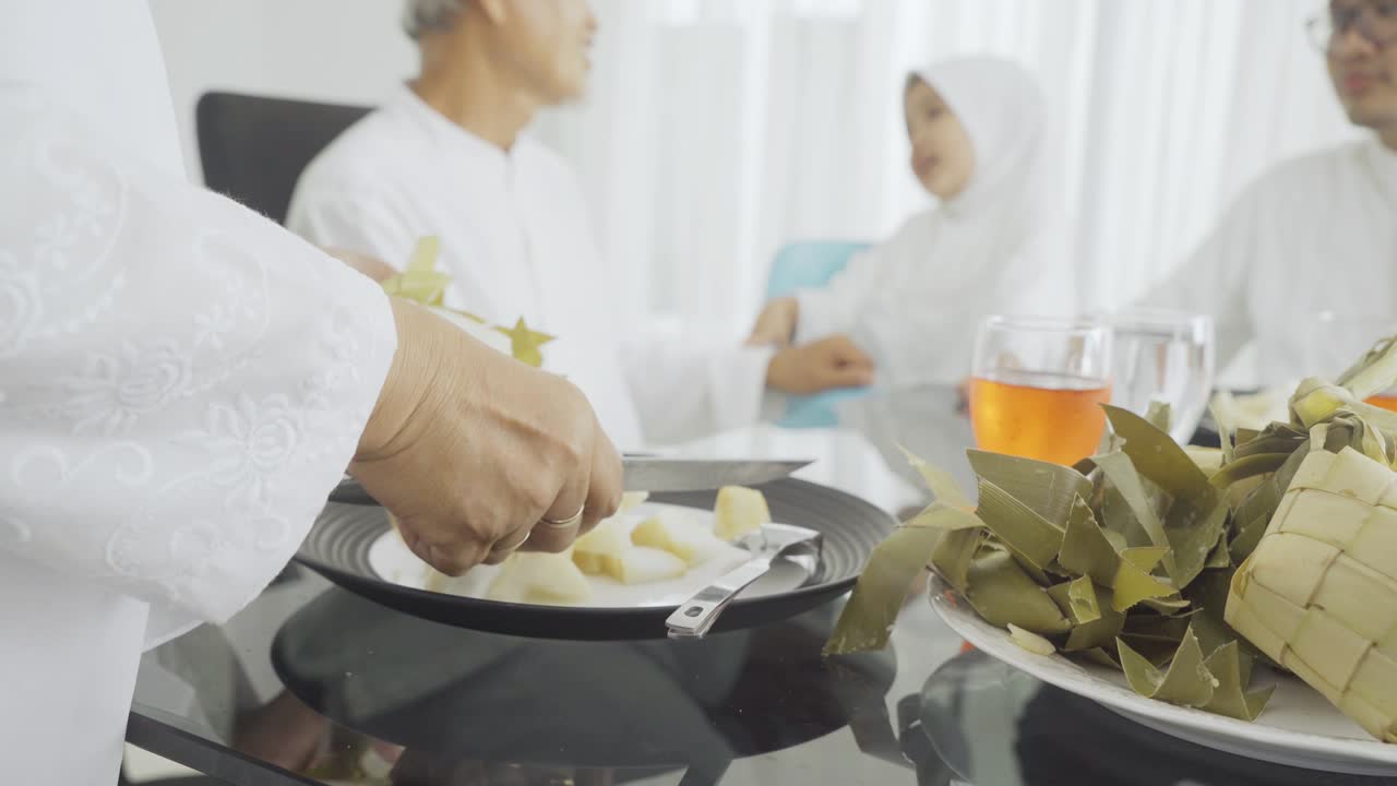 Eldre kvinne serverer tradisjonell mat Ketupat