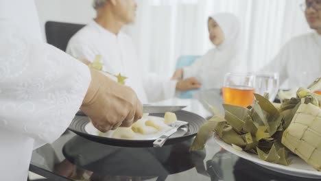senior woman hand serving traditional foods ketupat