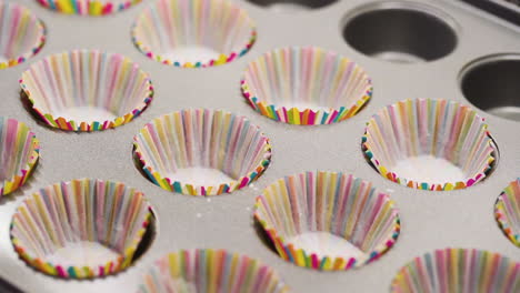 placing cupcake paper liners onto a backing tray