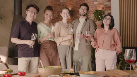 Un-Grupo-Multicultural-De-Amigos-Mirando-La-Cámara-Y-Sonriendo-En-Una-Cena