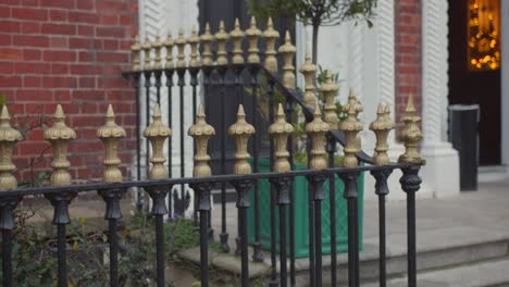 gold top garden railings of a classic black metal fence in dublin city, ireland