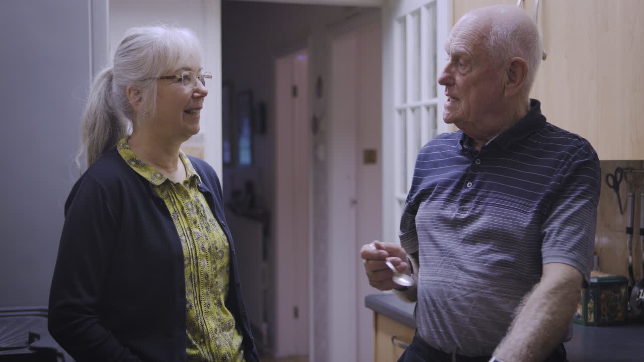 An older couple having a conversation in a kitchen