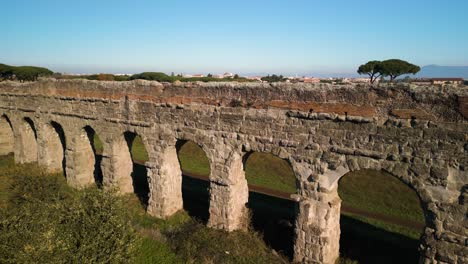 drone descends to reveal claudio aqueduct in rome, italy