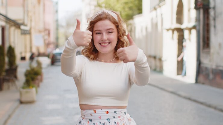 Fortunata donna che mostra il pollice in alto come segno positivo qualcosa di buono feedback positivo in strada della città