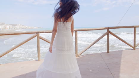 Dama-Juguetona-Vestida-De-Blanco-Disfrutando-En-El-Camino-De-La-Playa