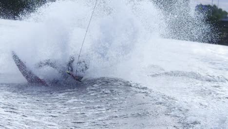 man riding on wakeboard falling into water. sportsman jumping on wakeboard