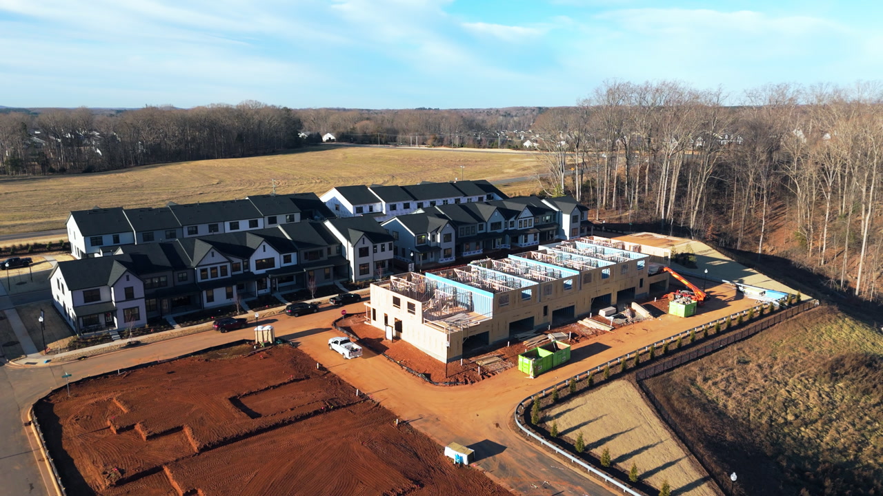 Residential Housing Construction Site With A Row Of Completed Townhouses And Units. Aerial Rotate Shot