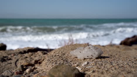 a salt crystal with a breaking dead sea waves in the blurred background in 100 frames per second