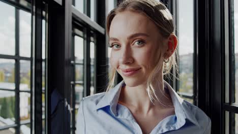 professional businesswoman standing confidently near large window in modern office, exuding corporate success through elegant pose and warm smile during inspiring montage sequence