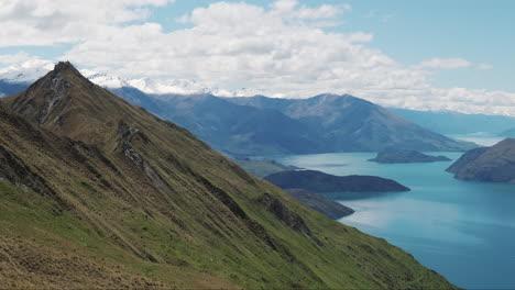 Slow-pan-beautiful-mountain-vista-looking-into-deep-blue-lake-valley