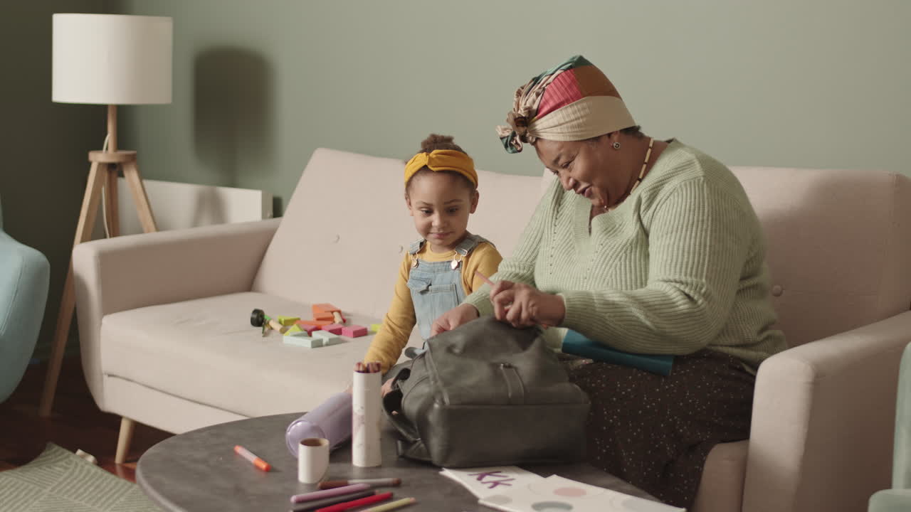 Grandmother Helping Her Granddaughter Packing School Bag