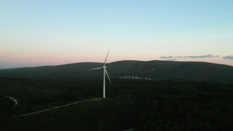 Wind-Turbine-Slowly-Spinning-Against-Blue-Sky-During-Sunset-In-Serra-de-Aire-e-Candeeiros,-Leiria-Portugal