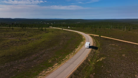 Luftaufnahme-Eines-Wohnmobils,-Das-Von-Einem-Berg-Herunterfährt,-In-Inari-Saariselka,-Finnland