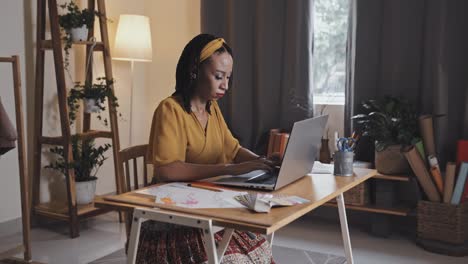 female designer working on laptop in studio