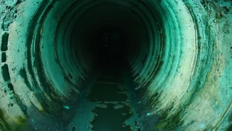 a view of the inside of a large pipe with water coming out of it