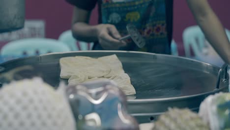 un hombre delgado prepara un delicioso pastel tradicional en una sartén grande