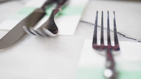 primer plano de un tenedor, un cuchillo y una cuchara en una mesa blanca