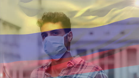 animación de agitar la bandera de colombia contra un hombre biracial ajustando su máscara facial en la calle