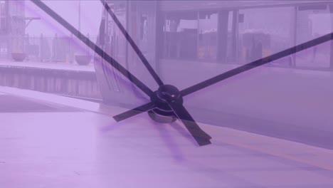 video compuesto de un primer plano de un reloj de tic-tac contra un tren detenido en una estación de tren