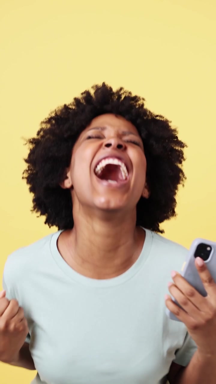 Excited African American Woman Reacting to Good News on Smartphone