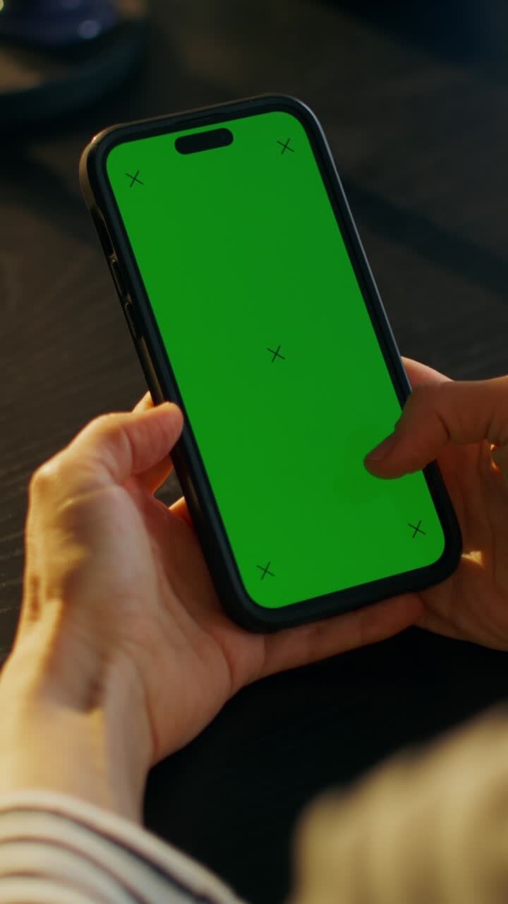 Persona che tiene uno smartphone con schermo verde