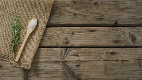 video of rosemary twig and spoon of salt on wooden background