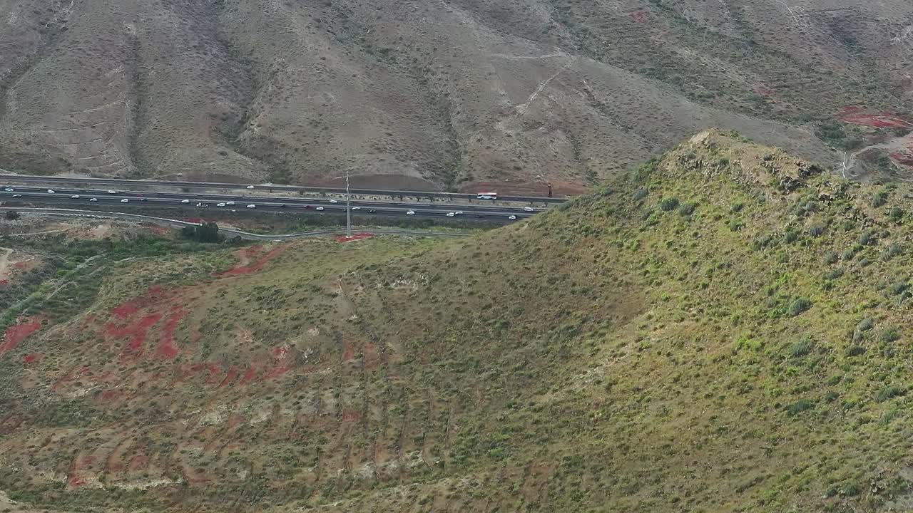 Vista di un pendio collinare a Tenerife, Spagna, con una strada in lontananza